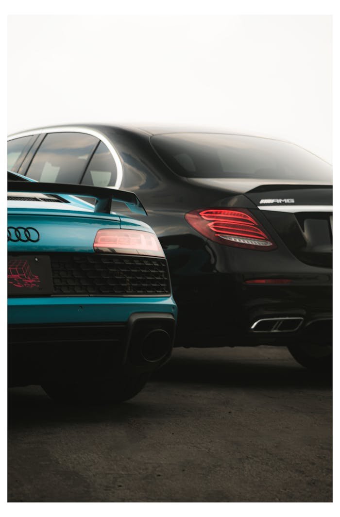 creative-02 A sleek modern shot of a luxury Audi and Mercedes-Benz parked side by side, showcasing elegance and performance.